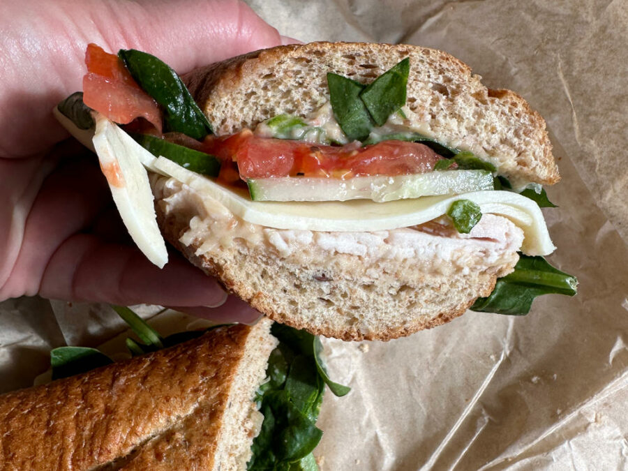 Sub sandwich with tomato, spinach, cucumber, cheese, and turkey 