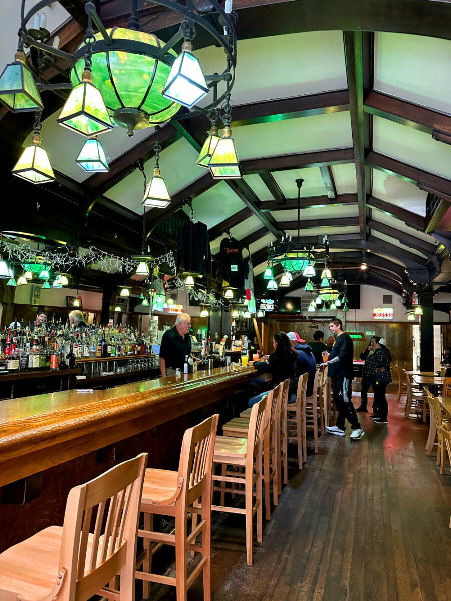 Green glass chandeliers and dark wood ceiling beams at the Doghouse Bar in Houghton, MI